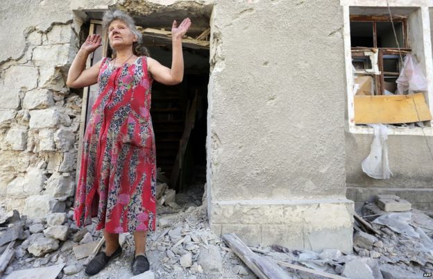 A woman reacts in front of her house destroyed as a result of shelling between Ukrainian forces and pro-Russian separatists on 10 August 2015 in Golmovsky village, Donetsk region