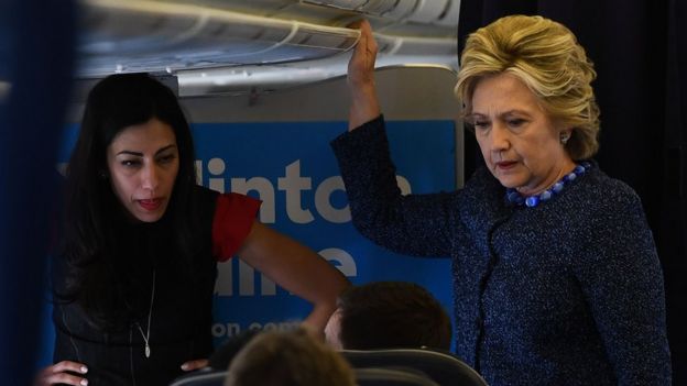 This file photo taken on October 28, 2016 shows US Democratic presidential nominee Hillary Clinton talking to staff as aide Huma Abedin (L) listens onboard Clinton