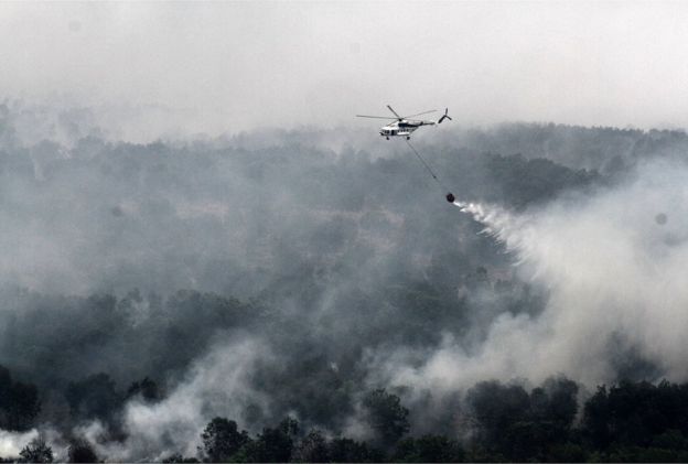 An Indonesian national board for disaster management MI-17 helicopter water-bombs a fire spot over Ogan Komering Ilir area, in South Sumatra province, on 17 October 2015