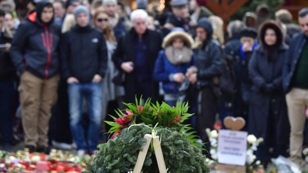 People mourn at a makeshift memorial for the victims of the Christmas market attack near the Kaiser-Wilhelm-Gedaechtniskirche (Kaiser Wilhelm Memorial Church) in Berlin on December 24, 2016