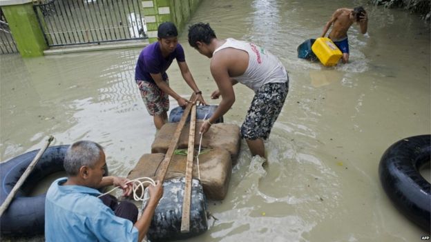Flood-affected residents make a raft to travel through floodwaters in Kalay, upper Myanmar's Sagaing region on 3 August 2015