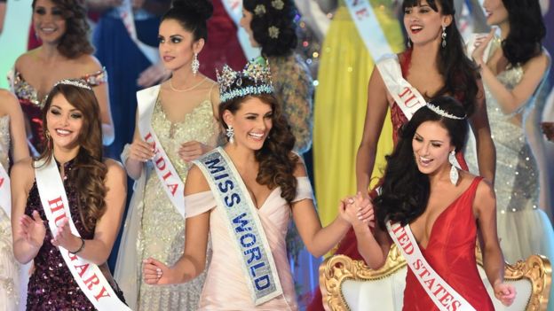 Miss South Africa and the 2014 Miss World, Rolene Strauss (C), dances with first runner up Miss Hungary Edina Kulcsar (L) and second runner up Miss United States Elizabeth Safrit (R) during the grand final of the Miss World 2014 pageant