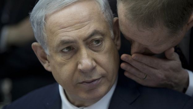 Israeli Prime Minister Benjamin Netanyahu listens to his spokesman Boaz Stambler (R) as he leads the weekly cabinet meeting