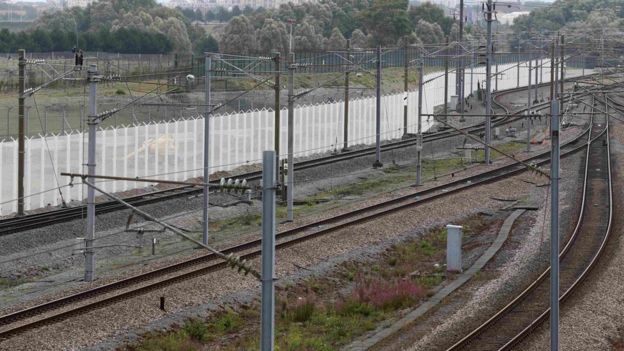 White security fence beside train tracks in Calais