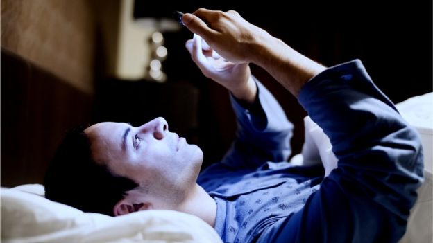 Man in bed using phone