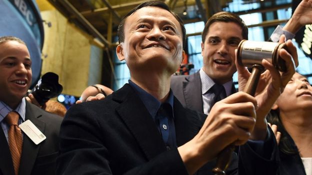 Chinese online retail giant Alibaba founder Jack Ma (C) holds up a gravel before ringing a bell to open trading on the floor at the New York Stock Exchange in New York on September 19, 2014