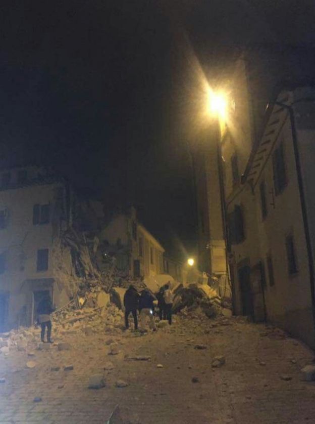 rubble from a collapsed building filling a lamp-lit street in Camerino, 26 October 2016