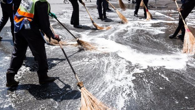 Workers clean up debris at the site of Monday's explosion on Tuesday