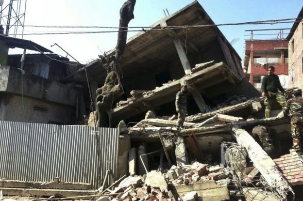 Indian soldiers inspect a house that collapsed in an earthquake in Imphal, capital of the north-eastern Indian state of Manipur, Monday, Jan. 4, 2016.
