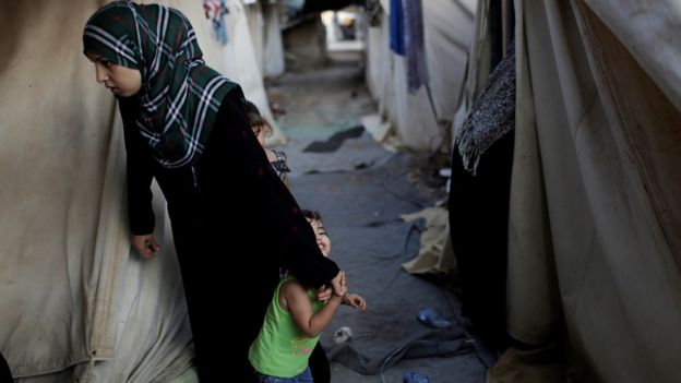 Mulher síria refugiada e seus filhos em campo de refugiados em Atenas, Grécia