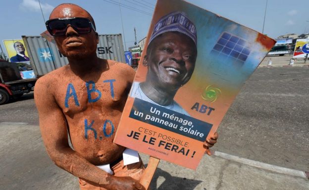A picture taken on March 4, 2016 shows a supporter with the party colours carrying a poster of presidential aspirant and former head of the West African Development Bank Abdoulaye Bio Tchane during a rally in Cotonou
