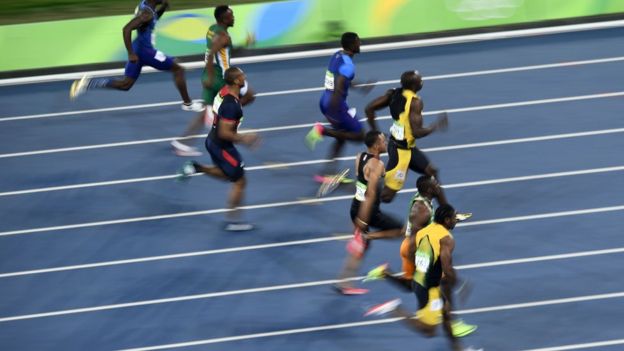 Usain Bolt junto a otros tres competidores por los 100 metros.