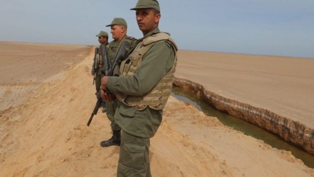 Tunisian soldiers stand on a sandbank during a presentation of the anti-jihadi fence, near Ben Guerdane, eastern Tunisia