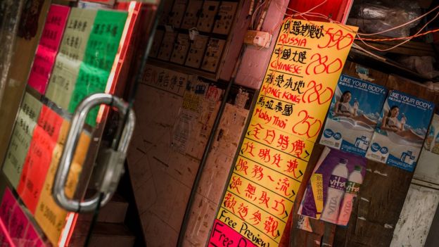 Signs on the front of a sex work business in Hong Kong