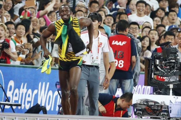 Usain Bolt of Jamaica stands up after being knocked over by a cameraman on a Segway after Bolt won the men's 200m final during the 15th IAAF World Championships at the National Stadium in Beijing, China 27 August 2015