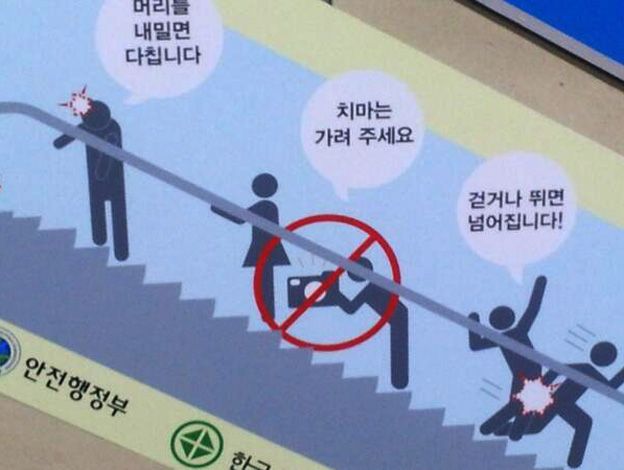 Afiche de advertencia en una escalera eléctrica de Corea del Sur