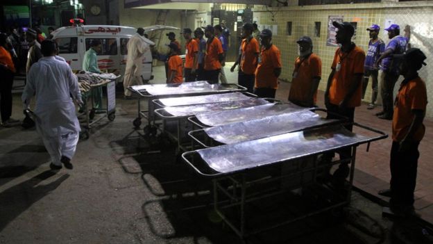 Staff members of a local hospital wait for casualties of bomb blast at a Sufi shrine, in Karachi, Pakistan