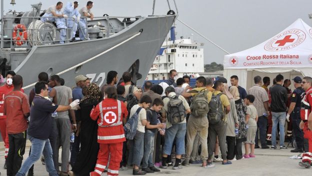 Migrants enter Red Cross tent after disembarking from Croatian Coast Guard ship at Augusta harbour, near Siracusa, Sicily, Italy. 16, Aug 2015.