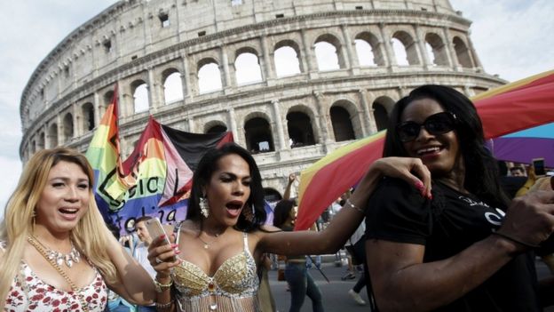 People march past the Coliseum during the Gay Pride parade in Rome, 11 June