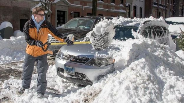 A man clears his car with a shovel near Central Park (24 January 2015)