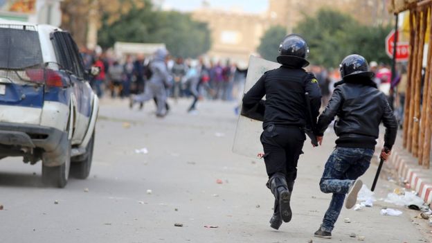 Riot policemen run after protesters during clashes in Kasserine, Tunisia January 21, 2016.