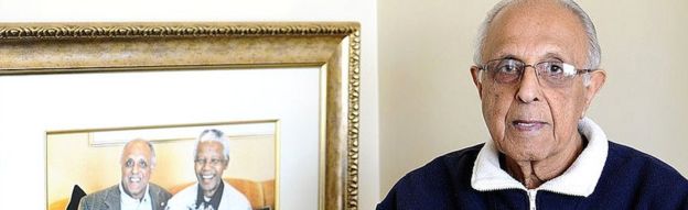 82-year-old Ahmed Kathrada, anti-apartheid activist and close friend of former South African President Nelson Mandela poses next to a picture of himself with Nelson Mandela on July 16, 2012