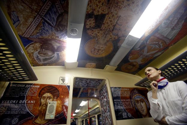 A train hostess stands in a train carriage decorated with the iconic figures as it departs from the Belgrade to Mitrovica, Kosovo at Belgrade's railway station, Serbia