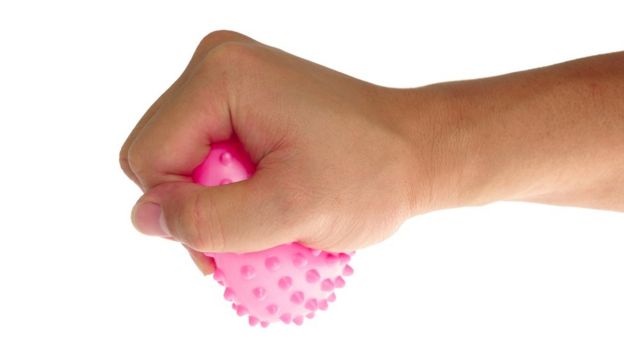 Una mano aprieta una pelota de goma.