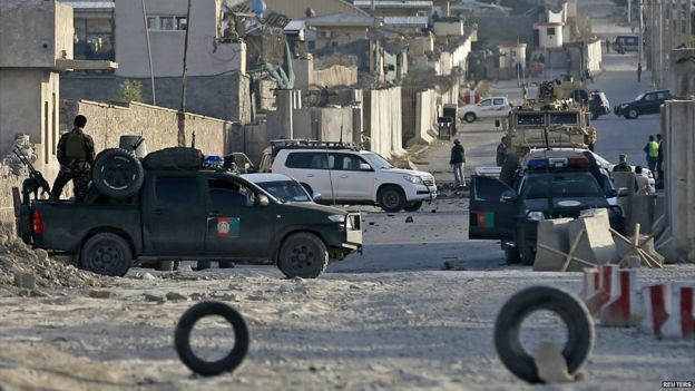 Afghans and foreigners inspect the site of an attack after an overnight battle outside a base in Kabul, Afghanistan - 8 August 2015