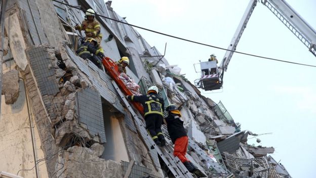 Rescue personnel work on a damaged building