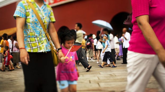 Niña con su madre en una plaza en Pekín