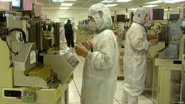 Workers at the local unit of Cypress Semiconductor monitor an automated assembly line for semiconductors in Laguna, 06 November 2003, in Laguna.