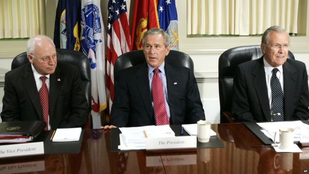 Former President George W. Bush sits between Dick Cheney and Donald Rumsfeld