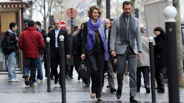Syrian president Bashar al-Assad and his wife Asma walk in a street of Paris in December 2010