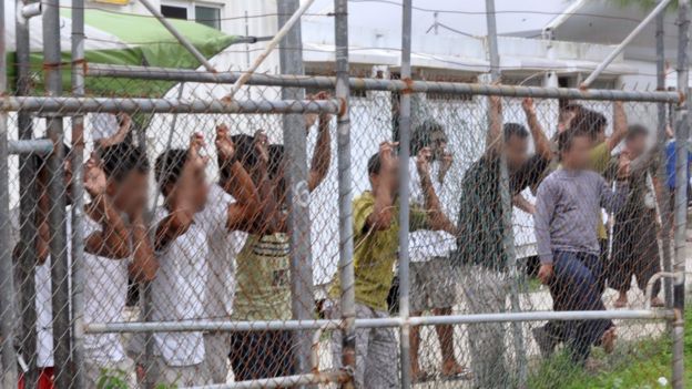 Asylum-seekers behind a fence at the Manus Island detention centre, Papua New Guinea, 21 March 2014