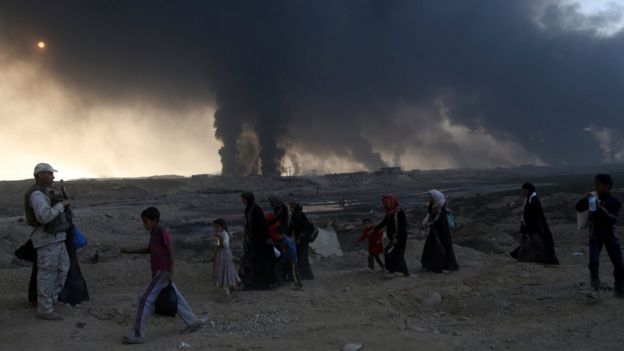People flee their homes during fighting between Iraqi security forces and IS near Mosul, 18 October