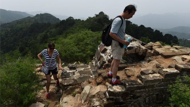 Tourists on an un-restored section of the wall