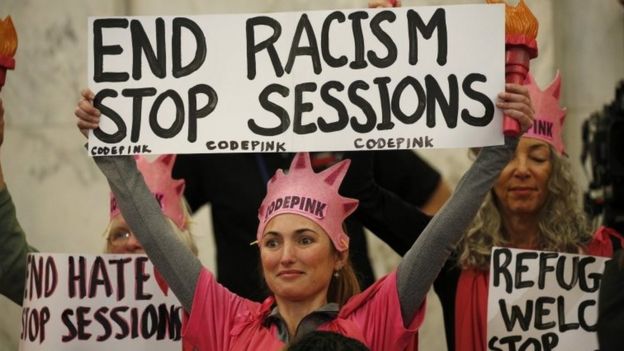 Protesters from the Code Pink activist group sit in on the confirmation hearing for Senator Jeff Sessions.