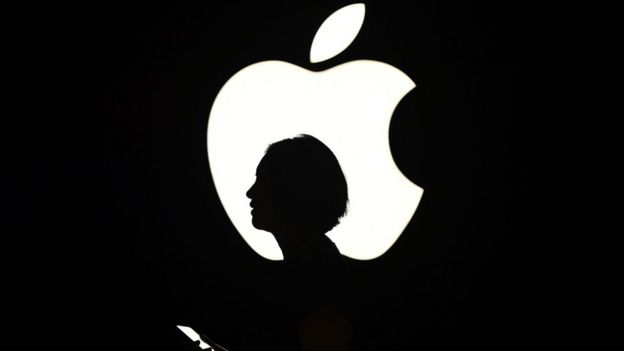 la silueta de una mujer frente a un logo de Apple