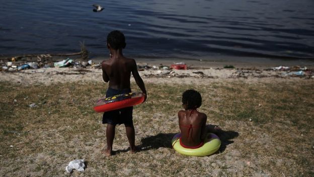Crianças olham para a Baía de Guanabara