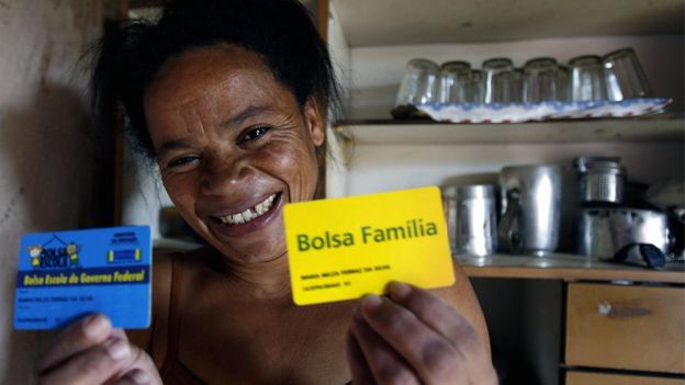 A woman holds her Bolsa Familia card