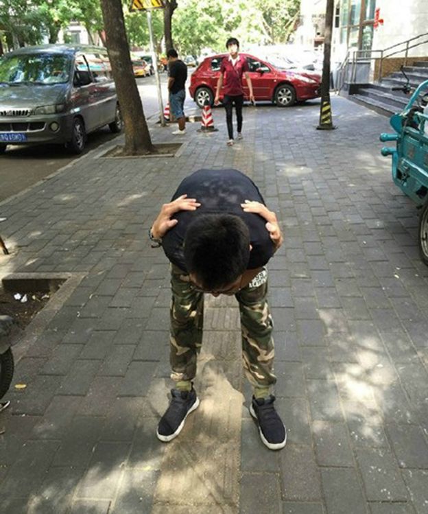 Chinese man stretches like Phelps on the pavement