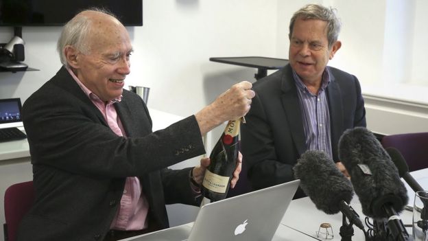 scientists at desk with bottle of champagne