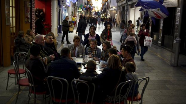 People sit at the terrace of a coffee shop during the day of reflection ahead of Spain's general election in Ronda