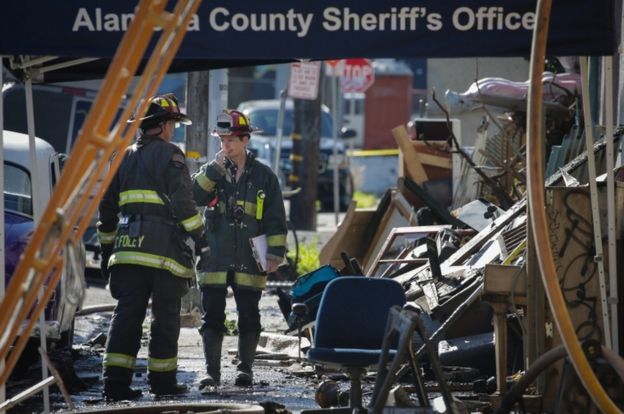 Firefighters work on the scene following an overnight fire that claimed the lives of at least nine people at a warehouse in the Fruitvale neighborhood on December 3, 2016 in Oakland, California