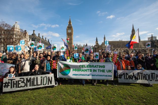 Protesters and migrant workers hold banners and flags as they demonstrate outside Parliament on 20 February 2017 in London