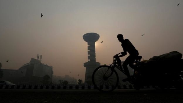 A rickshaw puller passes in front of a shopping mall amidst the heavy smog in New Delhi, India, October 31, 2016