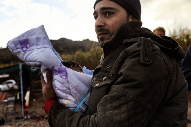 a man clutching a tiny baby to his chest, November 2015