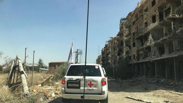 Image by Syrian Red Cross showing aid convoy passing badly-damaged buildings in Darayya, Syria - 1 June 2016