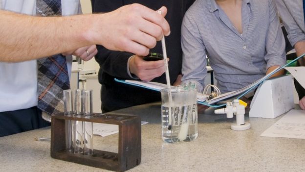 Close up hands and lab equipment